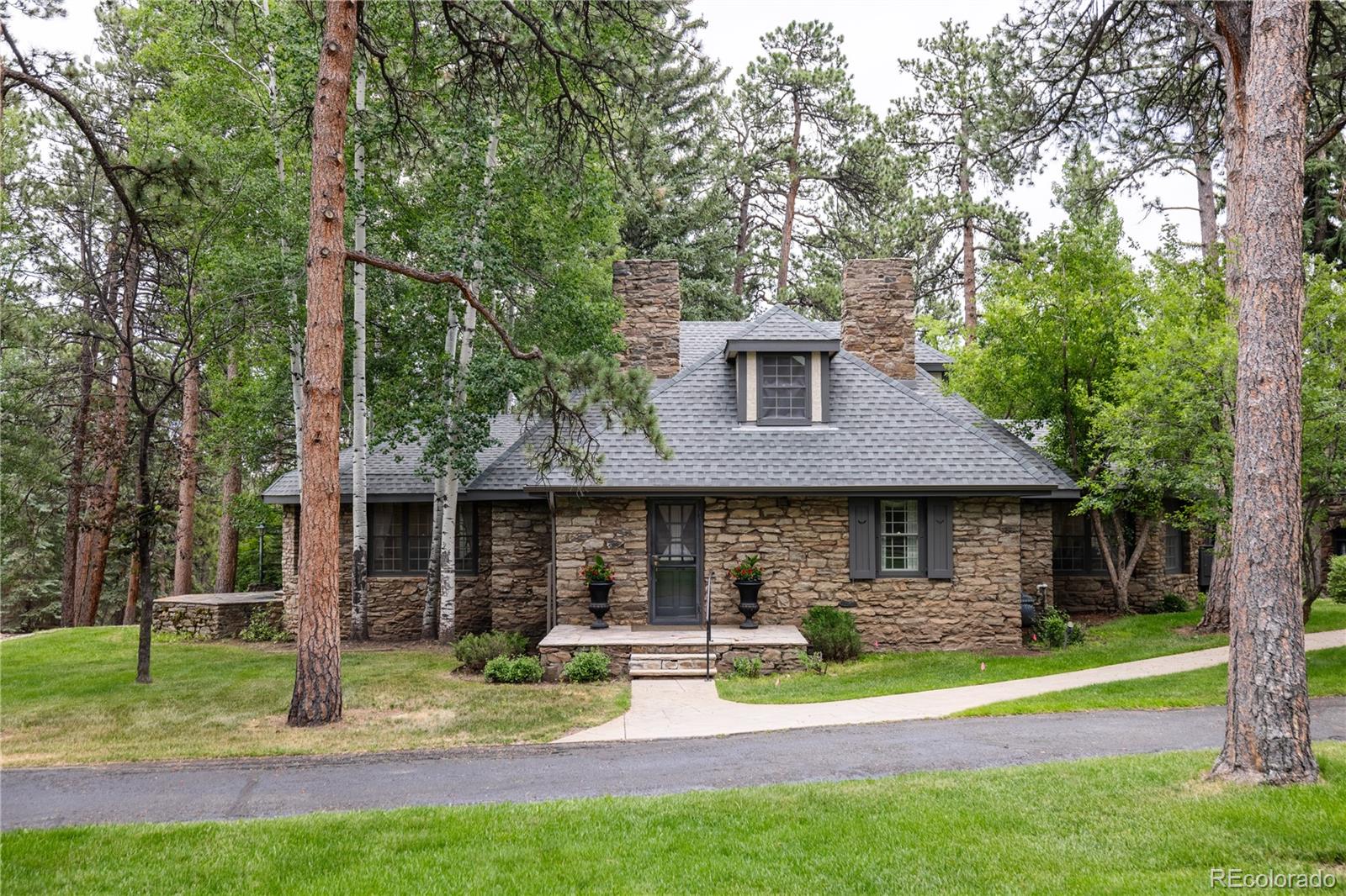 222 Greystone Road Evergreen, CO 80439 - Photo 14 of 31 a front view of a house with a yard table and chairs