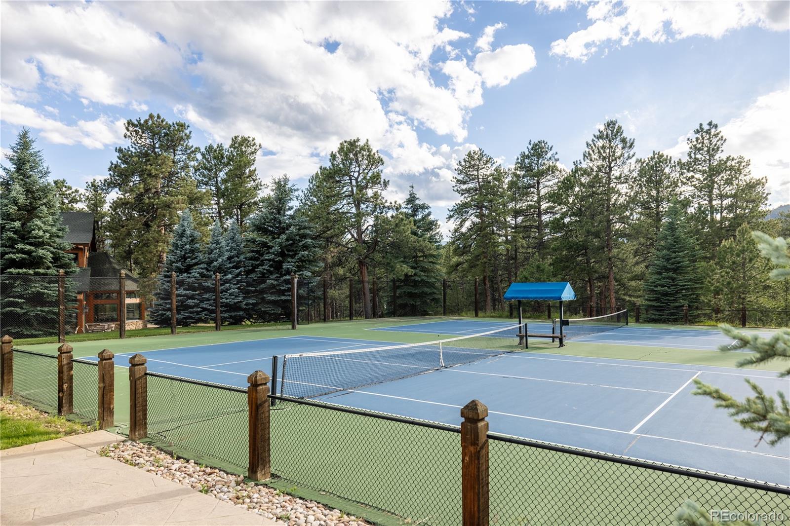 222 Greystone Road Evergreen, CO 80439 - Photo 17 of 31 a view of a tennis court with chairs