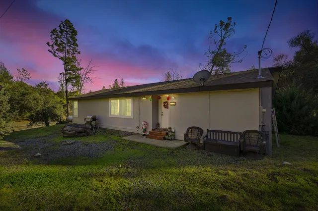 a backyard of a house with table and chairs