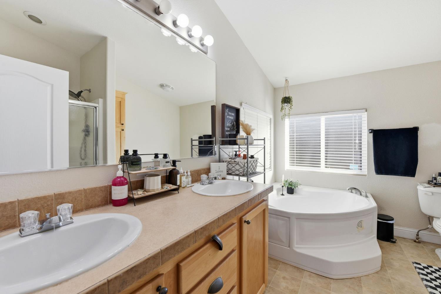 1160 Pleasant Valley Road Diamond Springs, CA 95619 - Photo 17 of 42 a bathroom with a double vanity sink double mirror and bathtub