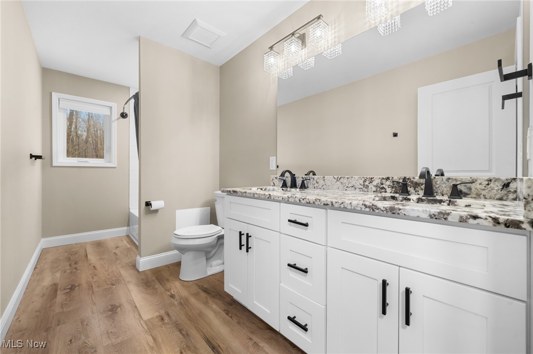 39600 Aurora Road Solon, OH 44139 - Photo 36 of 49 Full bathroom featuring double vanity, light wood-style flooring, and bathtub / shower combination