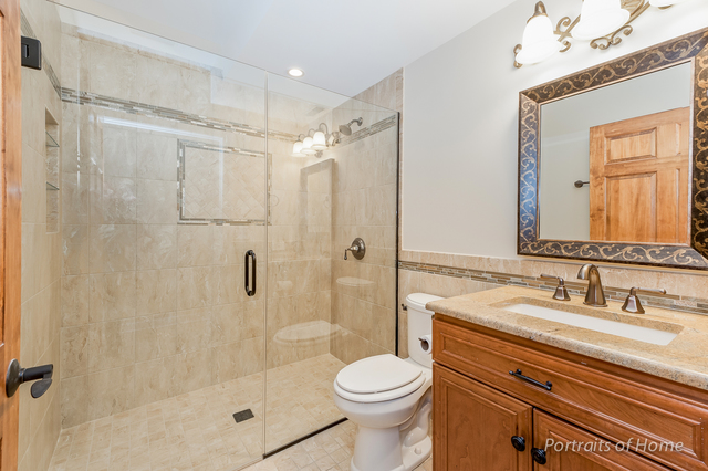 1015 Mackenzie Place Wheaton, IL 60187 - Photo 23 of 26 a bathroom with a shower sink vanity mirror and toilet