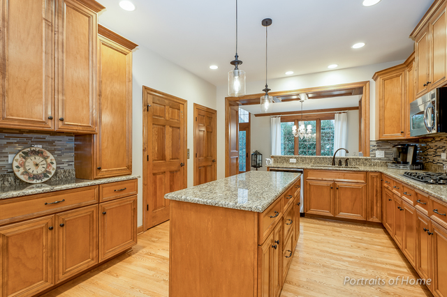 1015 Mackenzie Place Wheaton, IL 60187 - Photo 8 of 26 a kitchen with stainless steel appliances granite countertop a sink a stove and a refrigerator