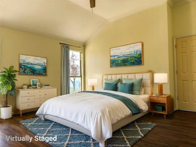 a spacious bedroom with a bed and a flat screen tv