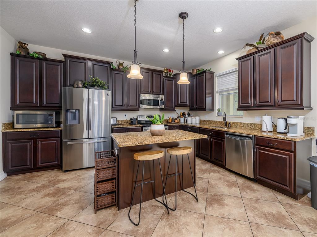 20213 Regal Fern Court Tampa, FL 33647 - Photo 11 of 65 a kitchen with kitchen island a counter space a sink and stainless steel appliances