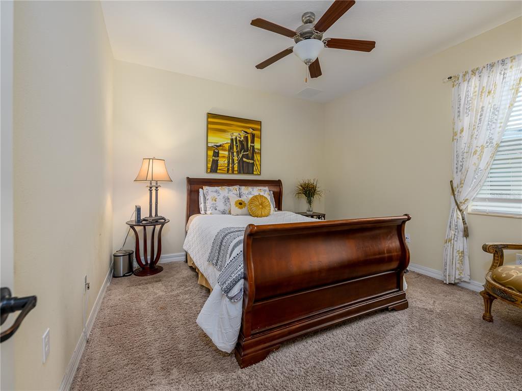 20213 Regal Fern Court Tampa, FL 33647 - Photo 27 of 65 a bedroom with a bed and a chandelier