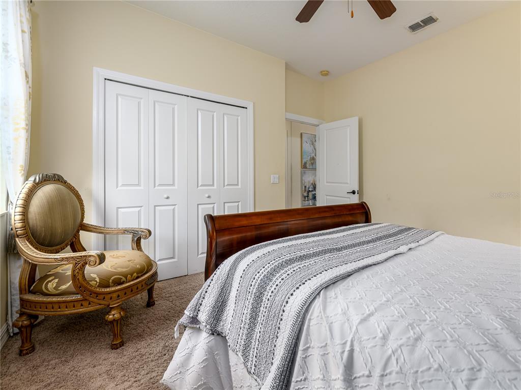20213 Regal Fern Court Tampa, FL 33647 - Photo 28 of 65 a bedroom with a bed a chair and a chandelier
