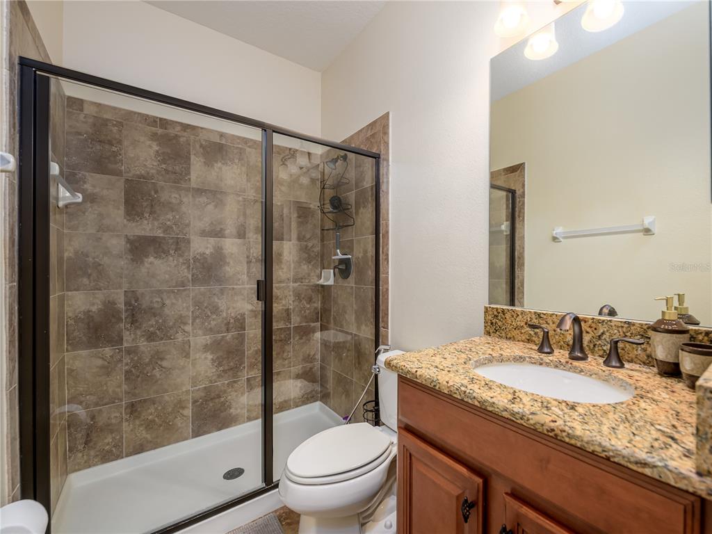 20213 Regal Fern Court Tampa, FL 33647 - Photo 36 of 65 a bathroom with a granite countertop sink toilet and shower