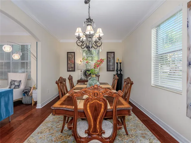 a dining room with furniture a chandelier and wooden floor