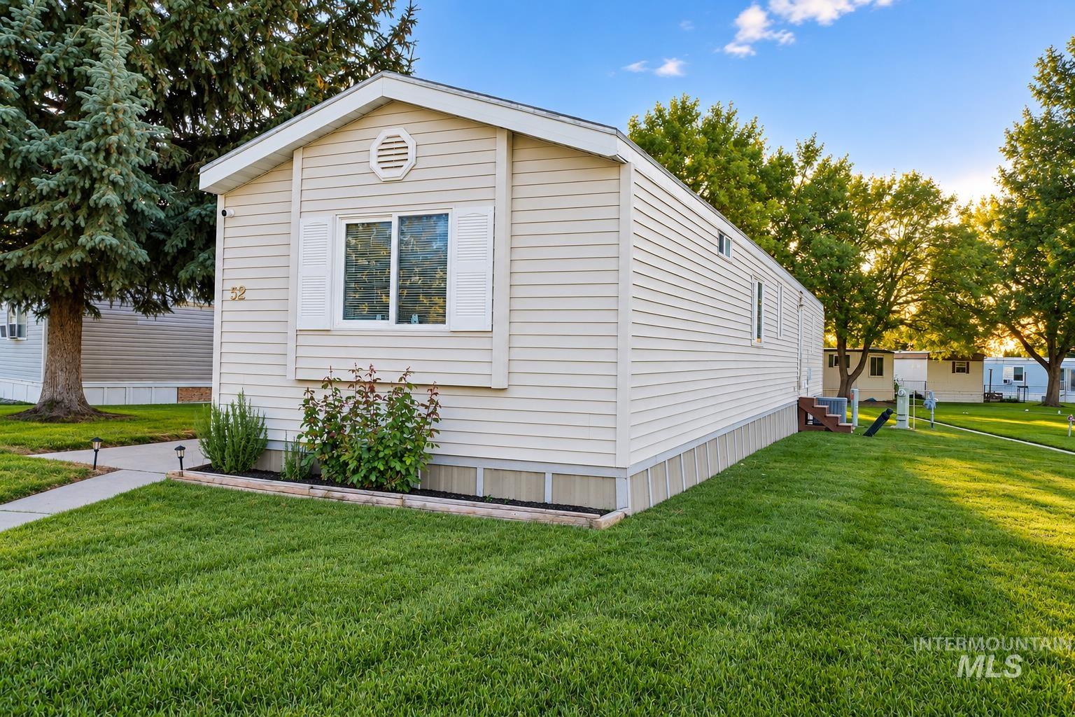 198 South Hills Road, Unit 52 Twin Falls, ID 83301 - Photo 17 of 22 Single-story residence featuring light-colored siding, a pitched roofline, white window shutters, and a well-defined front walkway