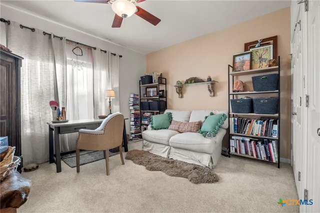 a living room with furniture and a book shelf