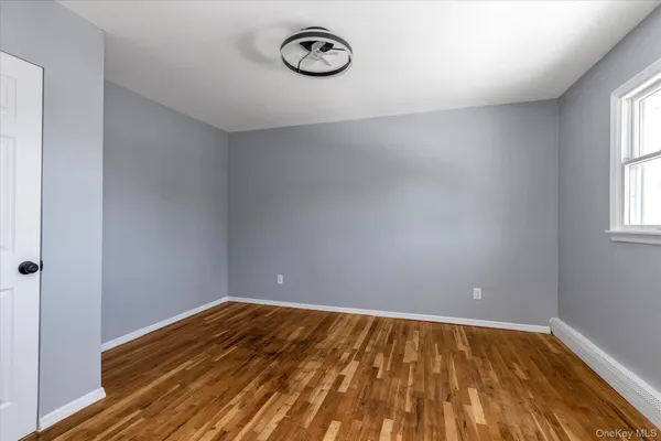 a view of a room with wooden floor and window