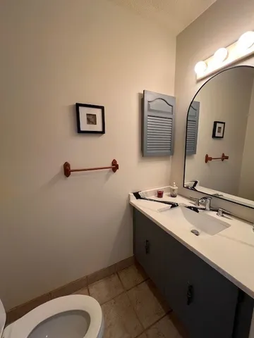 a bathroom with a sink mirror vanity and toilet