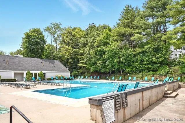 a view of house with swimming pool and a yard