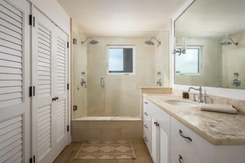 a bathroom with a granite countertop shower sink and mirror