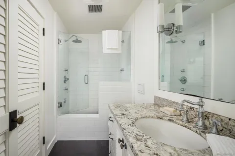 a bathroom with a granite countertop tub sink and shower