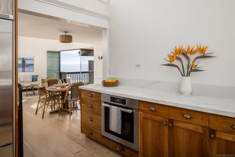 a kitchen with stainless steel appliances granite countertop a table and chairs in it