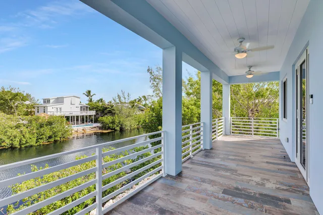 a view of a porch with wooden floor and iron stairs