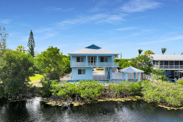 a front view of a house with a yard and lake view
