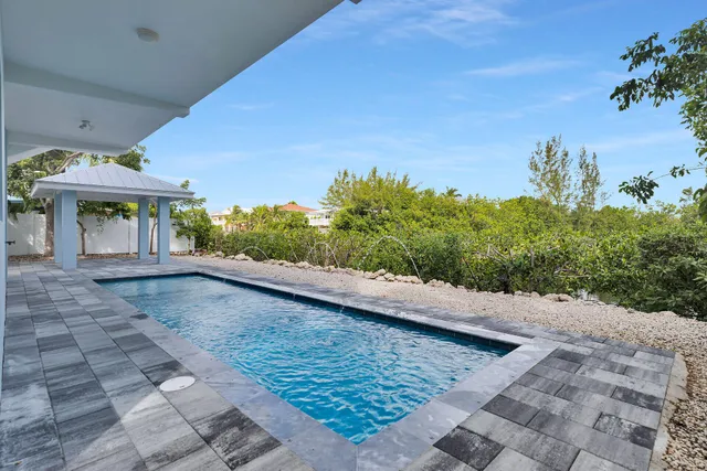 a view of a patio with a table and chairs under an umbrella