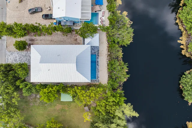 an aerial view of a house with a yard and garden in back