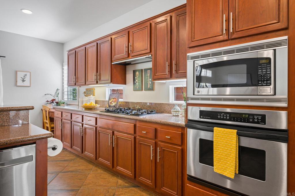 2107 Sun Valley Road San Marcos, CA 92078 - Photo 15 of 41 a kitchen with granite countertop a stove top oven microwave and cabinets