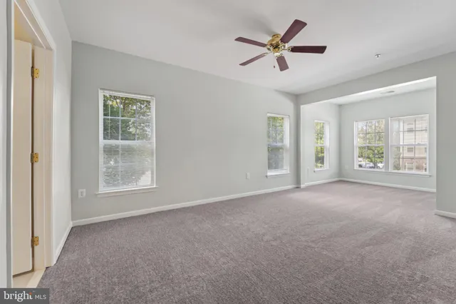 a view of a livingroom with a ceiling fan and window