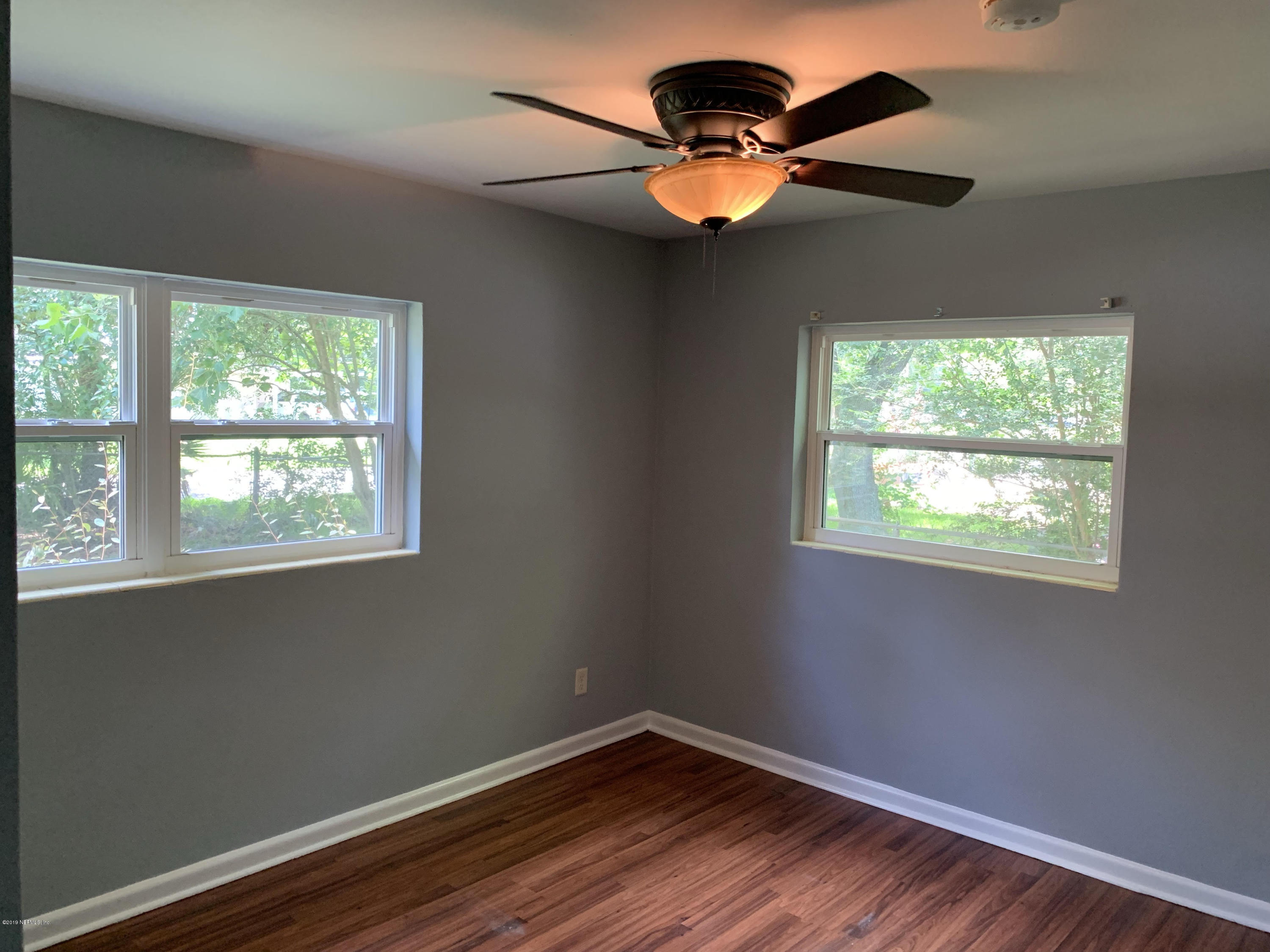 5304 Batley Road Jacksonville, FL 32210 - Photo 8 of 10 a view of an empty room with wooden floor and a window
