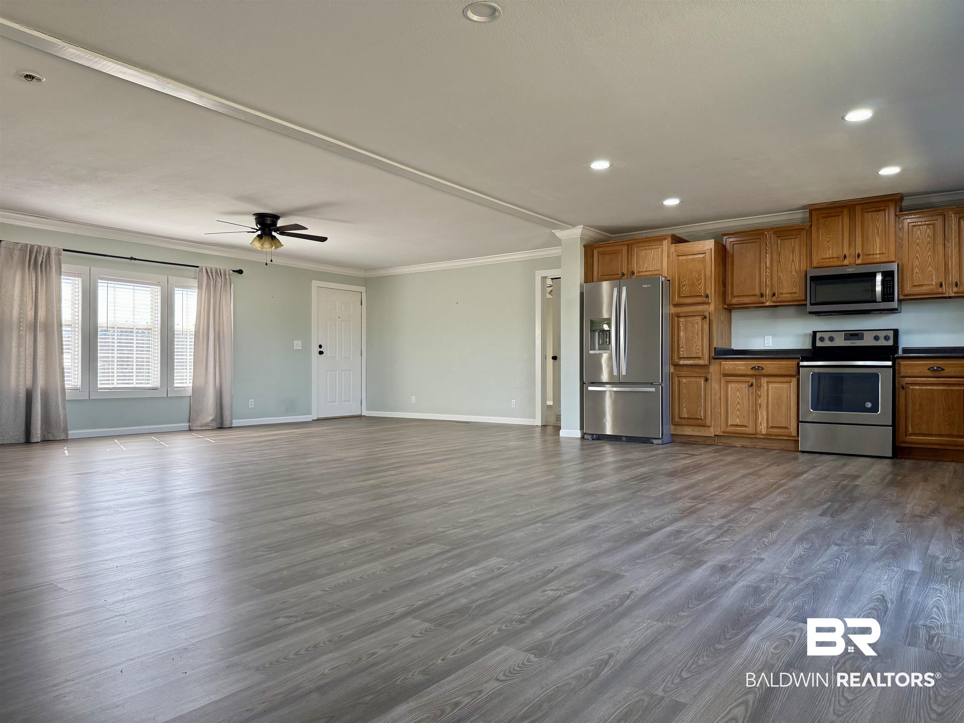 1064 Old Fannie Road Flomaton, AL 36441 - Photo 17 of 17 Kitchen featuring stainless steel appliances, wood finish cabinets, dark countertops, open floor plan, and ornamental molding