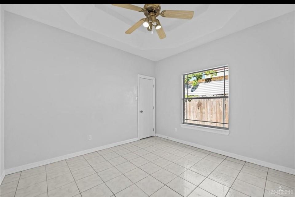 1900 Magnolia Street Mission, TX 78573 - Photo 11 of 25 Unfurnished room featuring a tray ceiling, ceiling fan, and light tile patterned flooring