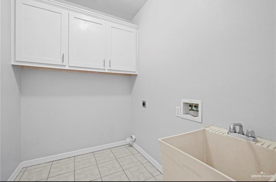 1900 Magnolia Street Mission, TX 78573 - Photo 22 of 25 Washroom with hookup for a washing machine, hookup for an electric dryer, light tile patterned flooring, and cabinet space