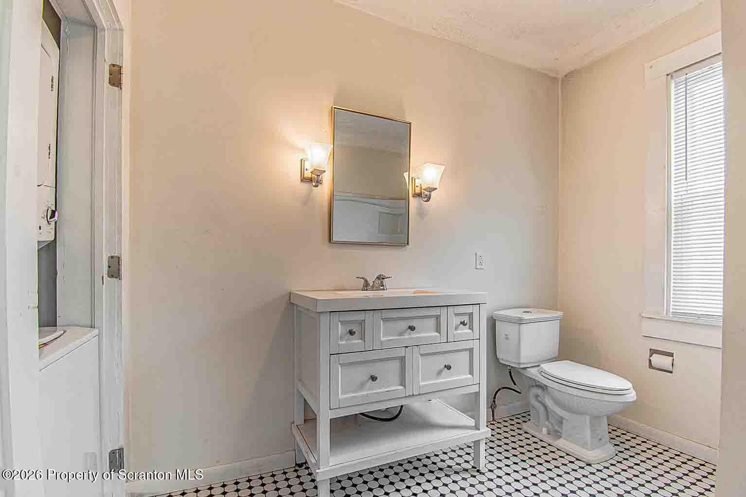 815 Monroe Avenue Scranton, PA 18510 - Photo 12 of 22 a bathroom with a toilet a sink and mirror