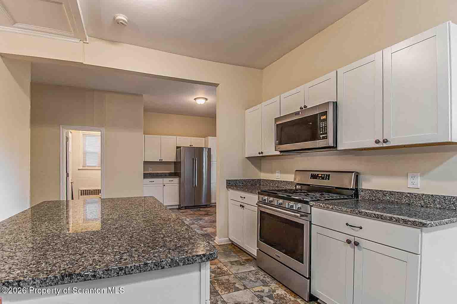 815 Monroe Avenue Scranton, PA 18510 - Photo 9 of 22 a kitchen with stainless steel appliances granite countertop a sink stove and microwave