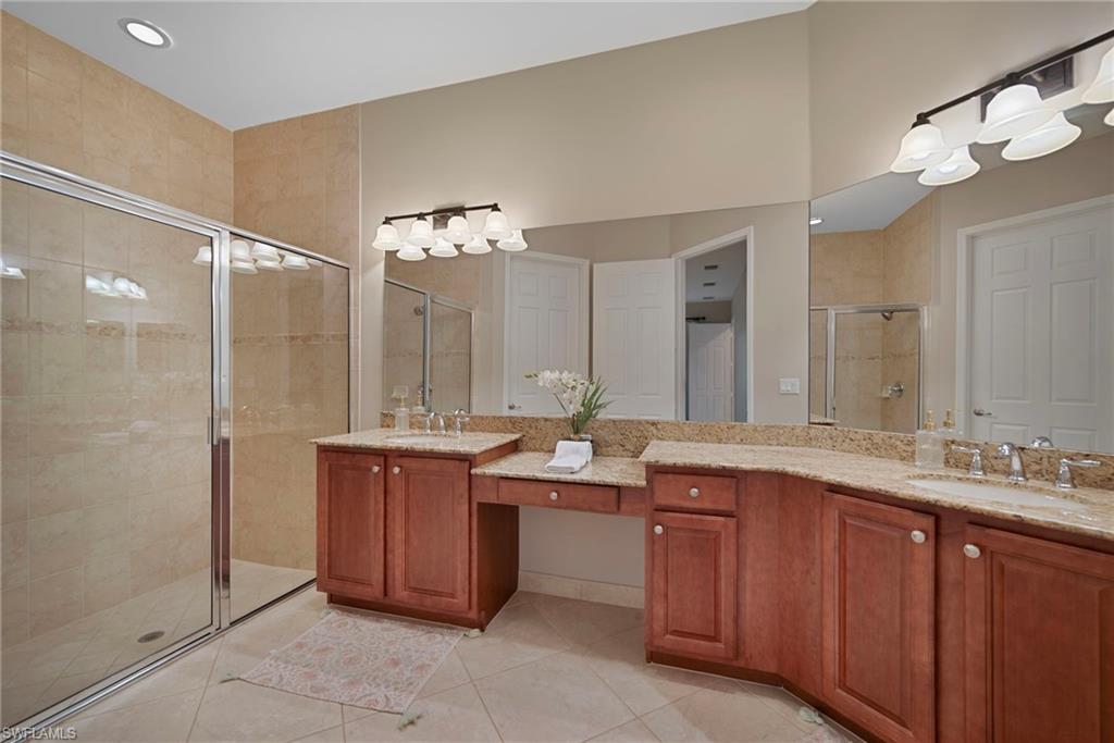 6522 Monterey Point, Unit 101 Naples, FL 34105 - Photo 10 of 29 a spacious bathroom with a granite countertop sink mirror and a