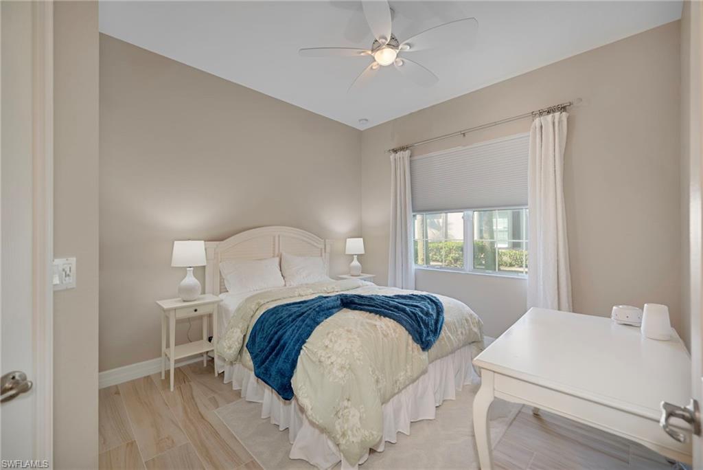 6522 Monterey Point, Unit 101 Naples, FL 34105 - Photo 11 of 29 a bedroom with a bed and a table