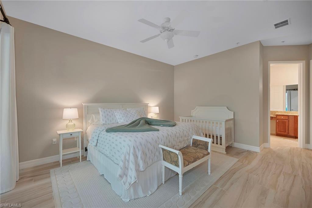 6522 Monterey Point, Unit 101 Naples, FL 34105 - Photo 9 of 29 a bedroom with a bed and a table