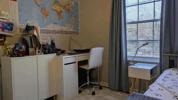 a view of a workspace with furniture and a window