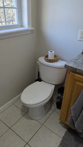 a white toilet sitting next to a window