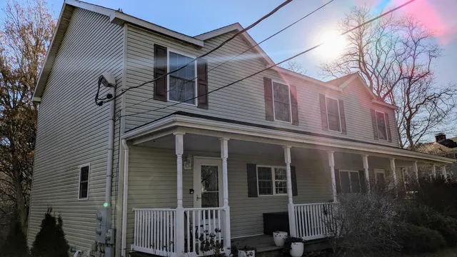 a view of a house with a yard and potted plants