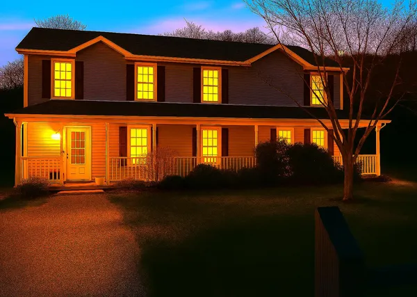 a view of a brick house with many windows and a yard