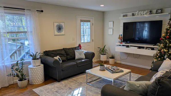 a living room with furniture a flat screen tv and a window