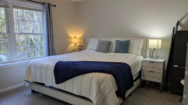 a bedroom with a bed a mirror and a window