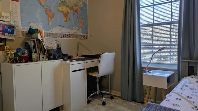 a view of a workspace with furniture and a window