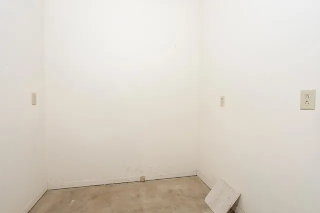 a view of an empty room with a fireplace and cabinet