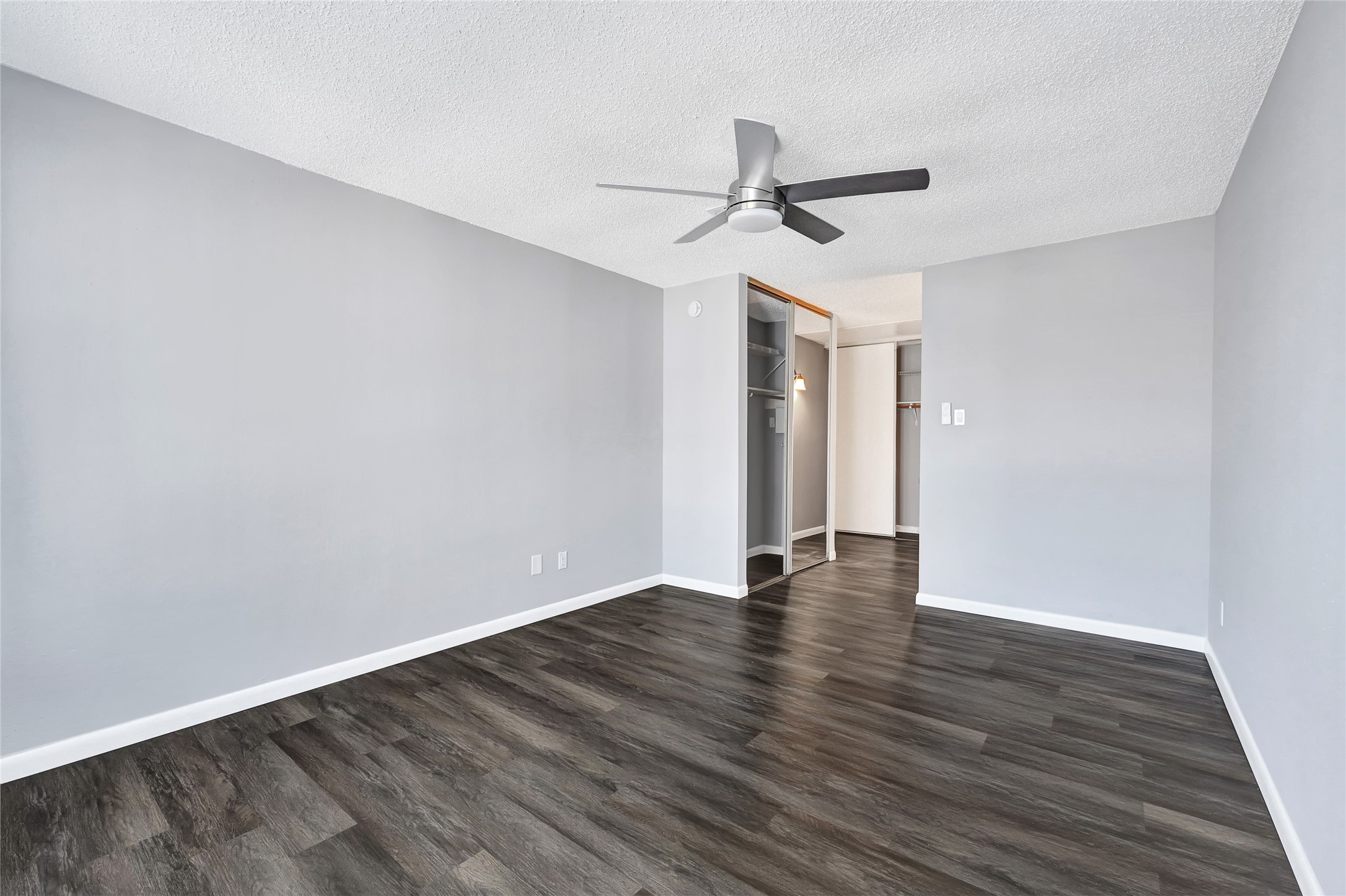 12111 Lemon Ridge Lane, Unit 121 Houston, TX 77035 - Photo 7 of 25 a view of an empty room with wooden floor and a ceiling fan