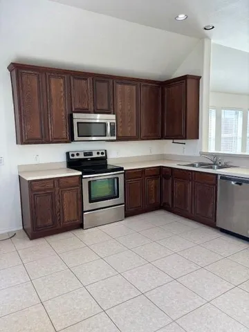 a kitchen with stainless steel appliances a stove a sink a microwave and a refrigerator