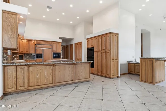 an empty room with windows fireplace and a chandelier fan