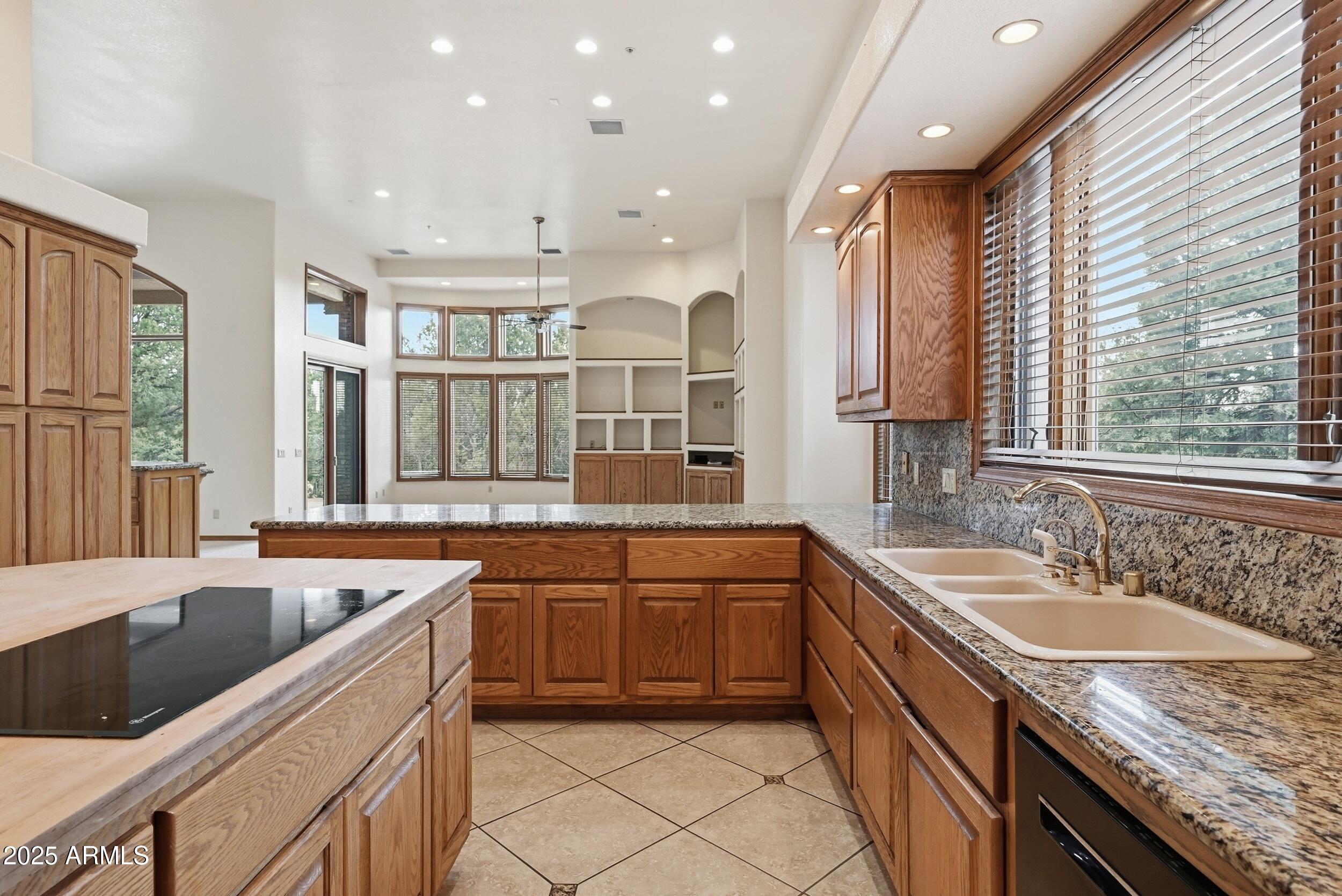 1606 Becky Circle Payson, AZ 85541 - Photo 21 of 58 a large kitchen with granite countertop a sink and dishwasher wooden cabinets with a granite countertops