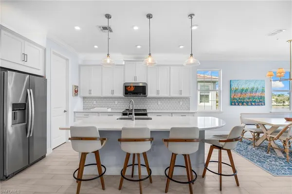 a kitchen with stainless steel appliances granite countertop a stove a refrigerator a microwave oven a sink with a dining table and chairs