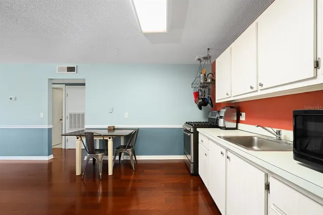 a kitchen with a table chairs and a wooden floor